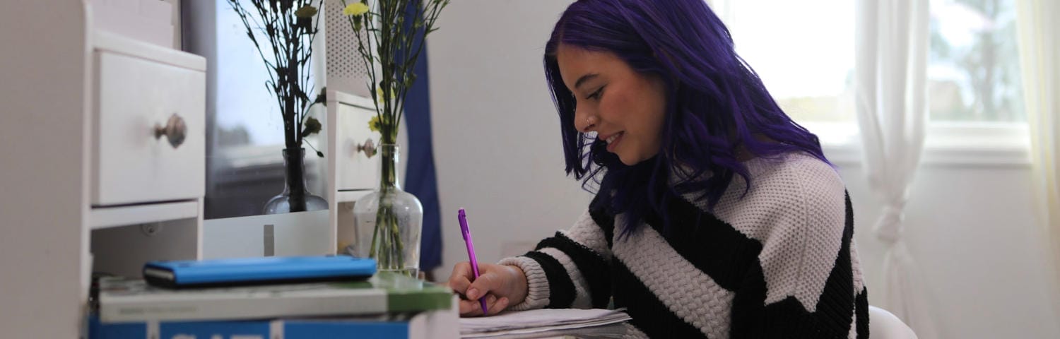 Student taking notes at home
