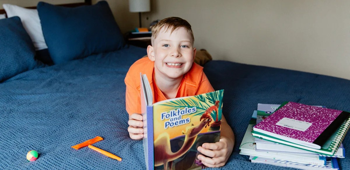 little boy smiling with notebook