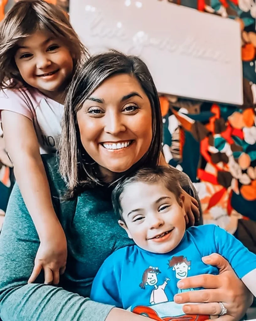 mom with their two kids smiling while taking a picture